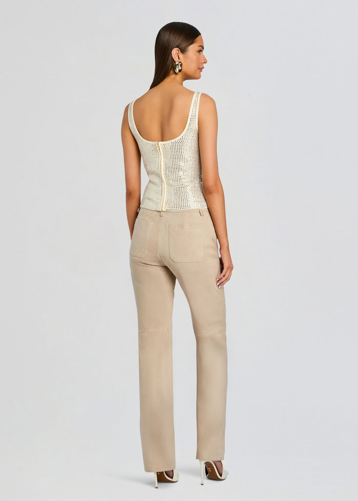 Back view of the model in a cream embellished top with a center zipper, paired with beige trousers media 5 of 5