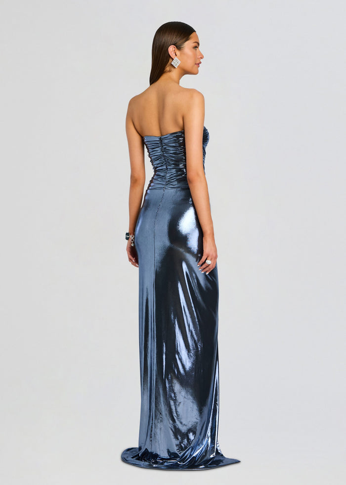 Back view of the Maytal Dress on a model strapless metallic blue gown with ruched back and floor length drape media 4 of 5