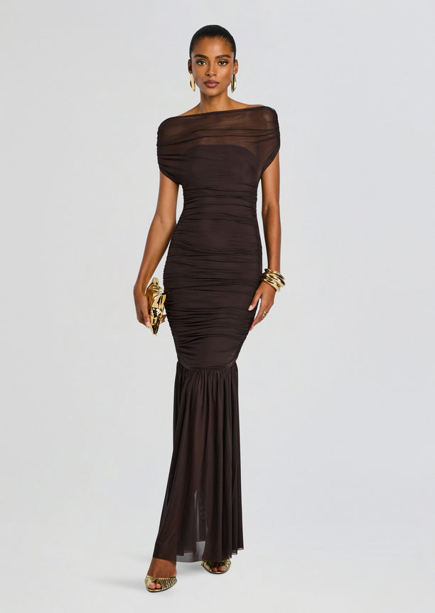 Front view of a chocolate Noel Gown with off the shoulder sheer neckline, ruched silhouette, and sheer lower skirt