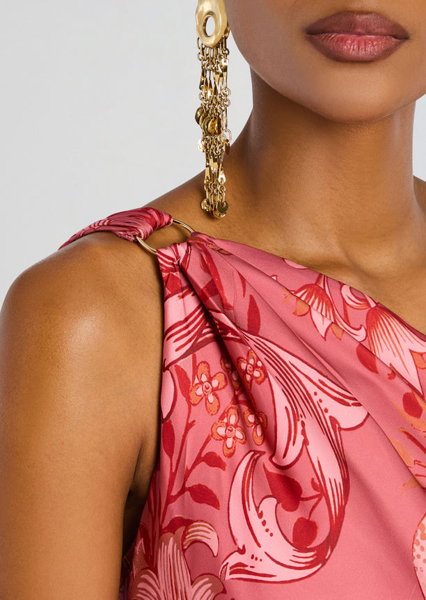Close up of a pink floral Vine One Shoulder Sash Dress with a wrapped shoulder strap and a gold dangling earring