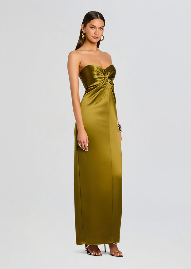 Full-length view of the olive satin strapless dress on a model with gold jewelry and strappy sandals