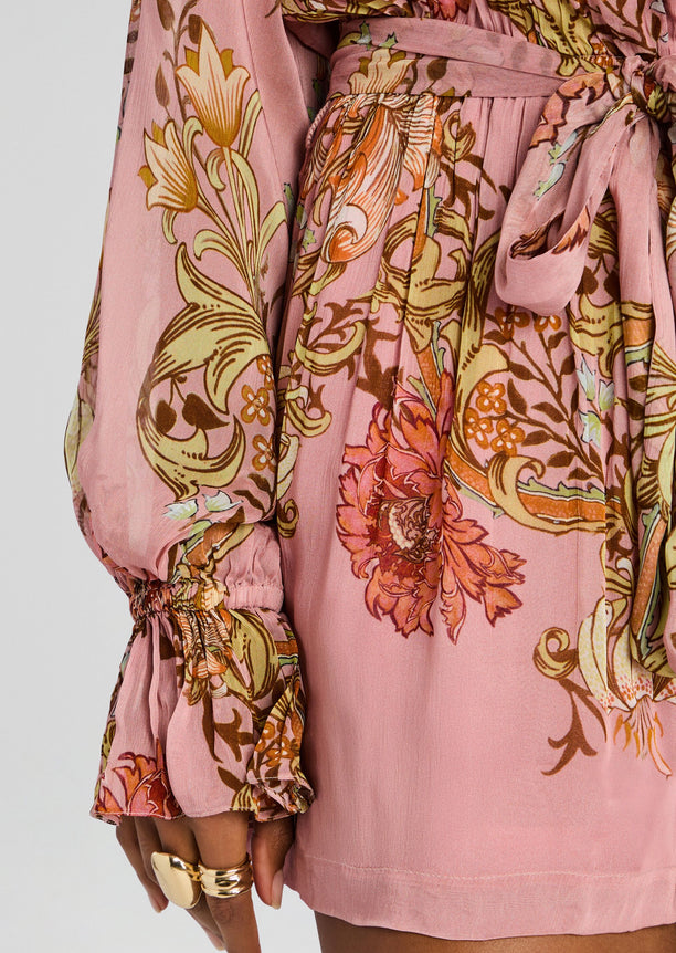 Close up on the waist area of the pink floral romper, showcasing the tie belt and vibrant botanical print.