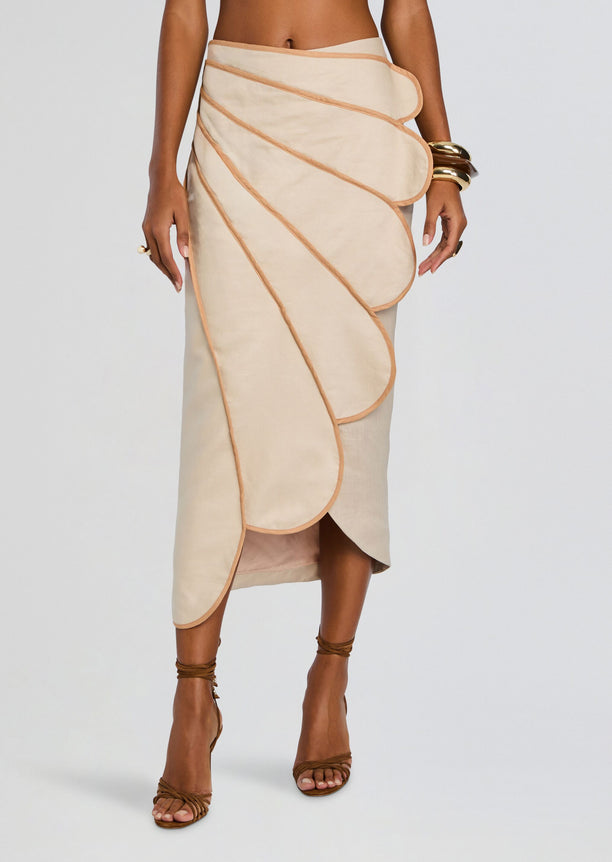 Beige wrap skirt with layered scalloped panels and peach piping.