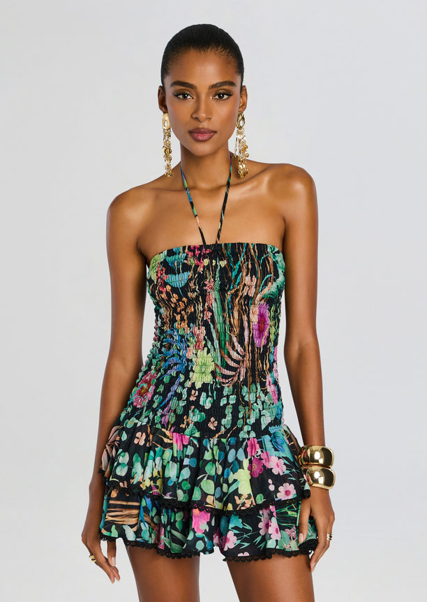 Front view of a model in the Aeris Short Dress a strapless smocked floral mini with a halter neck and tiered ruffle hem.