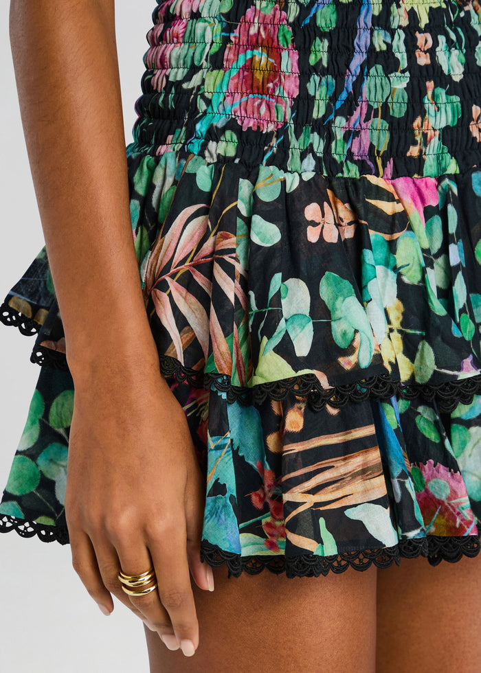 Close up of Aeris Short Dress waist and hem showing smocked detailing and colorful floral print with black lace trim. media 2 of 5