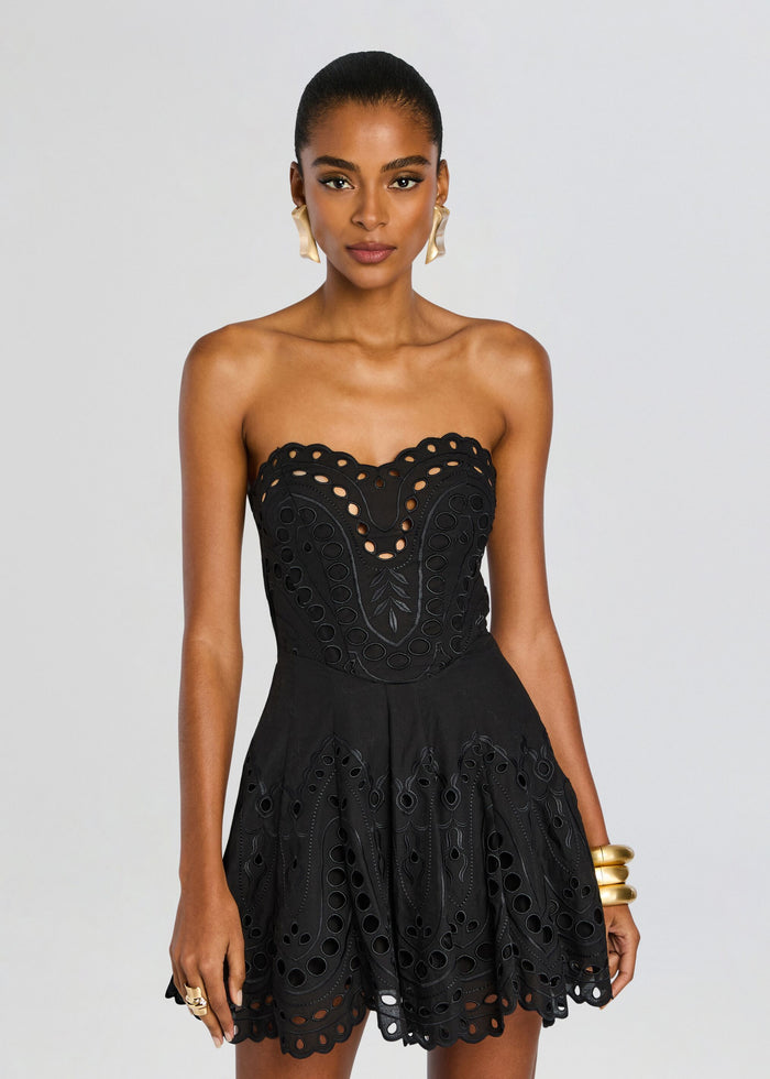Front view of Bail Short Dress in black featuring a strapless structured bustier with eyelet cutouts and a scalloped hem. media 5 of 5