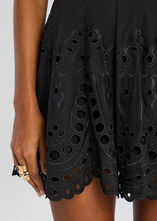 Close-up of the Bail Short Dress showing intricate black eyelet embroidery and a scalloped hem.