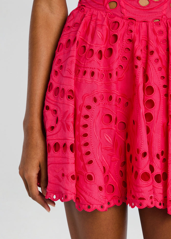 Close up of bright pink fabric showing eyelet embroidery and scalloped edge detailing from the Sandlight Dress. media 2 of 5