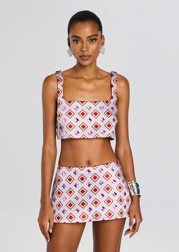 Model wears Thalisa Embellished Top and matching patterned mini skirt in pink geometric print.
