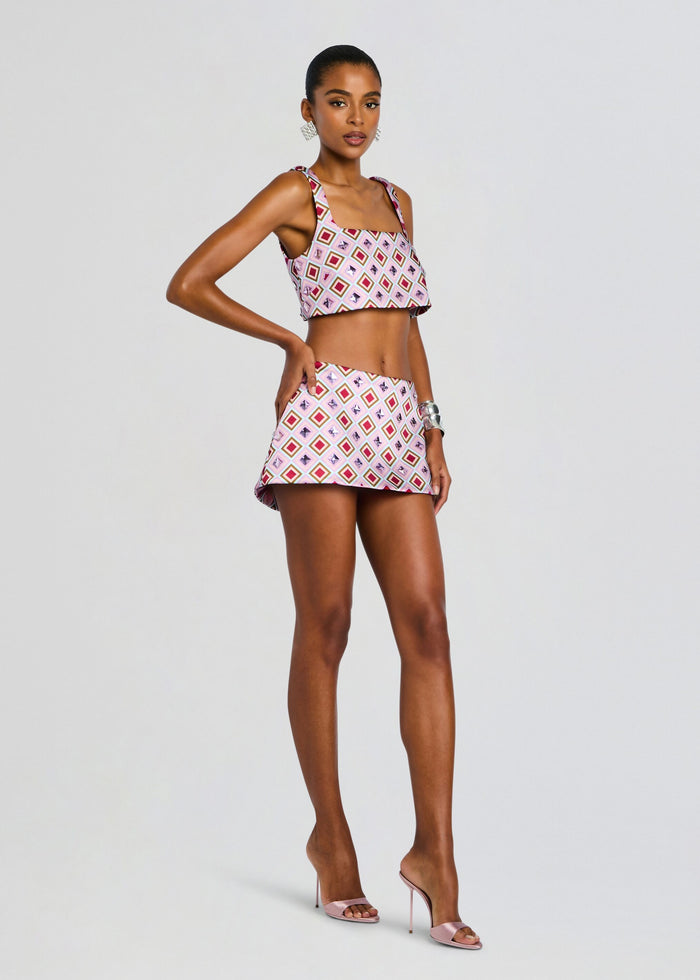 Full-length model in Ophelie Embellished Skort set with matching top and pink strappy heels in a studio shot media 4 of 6