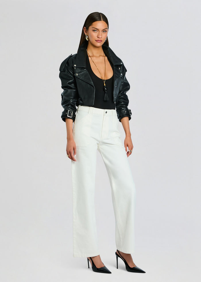 Full-length model wearing white Angelique denim pants with black top and leather jacket media 4 of 5