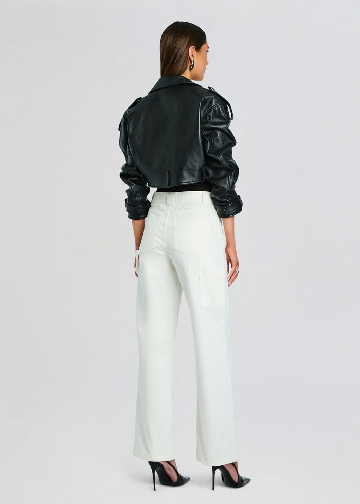 Back view of a model in white Angelique denim pants paired with a black leather jacket and black heels media 5 of 5