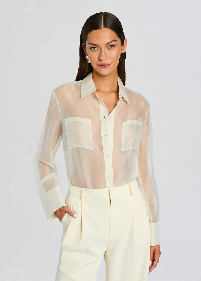 Model wearing sheer cream Estella Silk Top with two front pockets and long sleeves. media 1 of 5