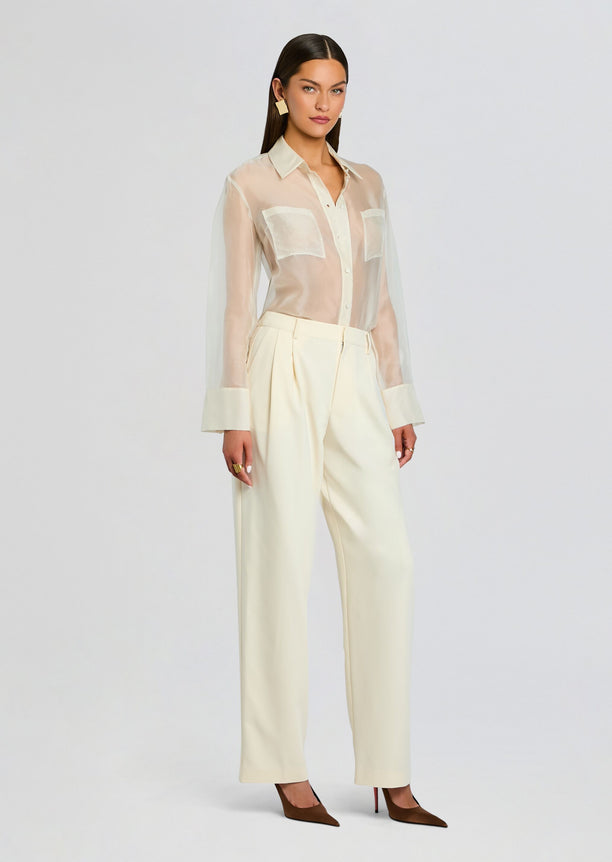 Full-length model wearing the Sonya Pant outfit with a sheer cream blouse tucked into cream wide-leg pants and brown heels.