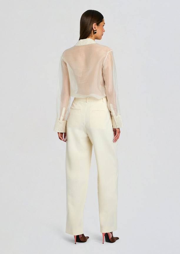 Back view of a model wearing ivory Sonya Pant with back pockets and wide legs.
