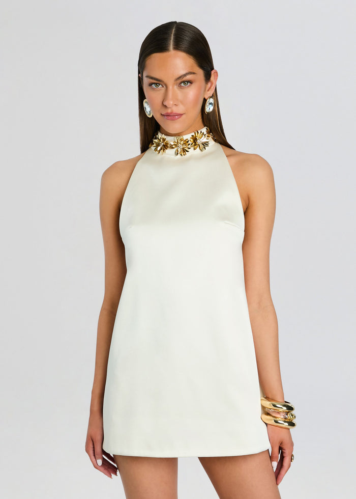 Cream halter mini dress with a gold floral neckline embellishment on a model. media 5 of 5
