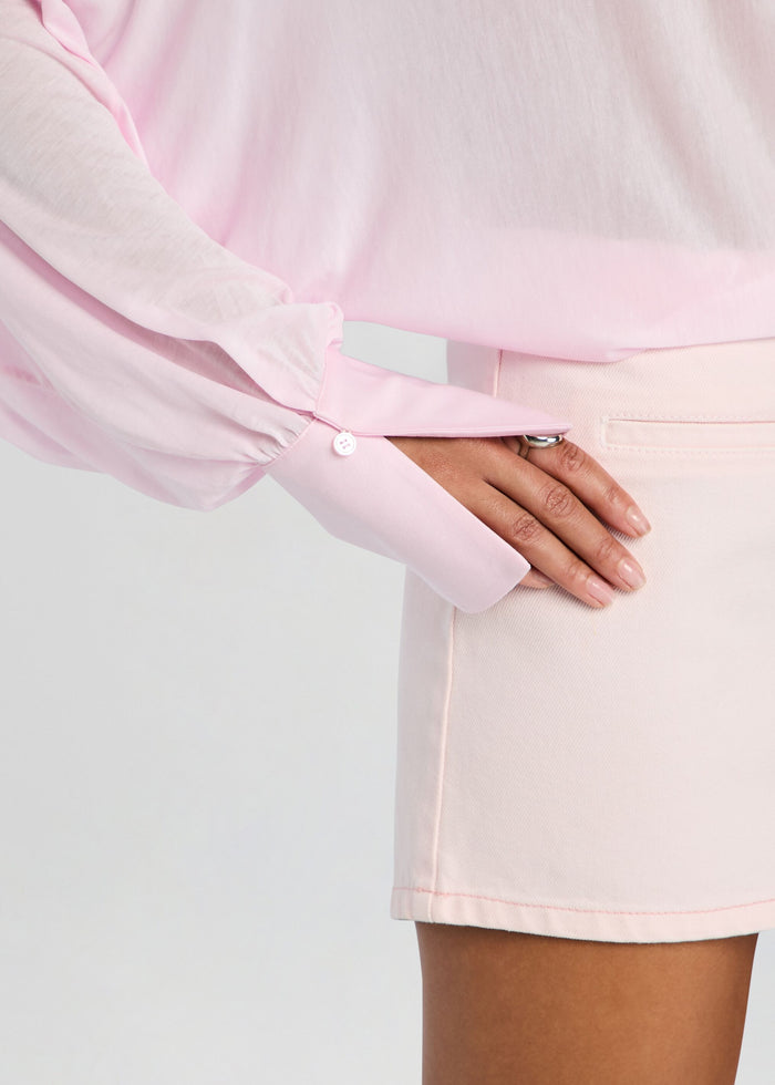 Hawkes bodysuit sleeve in soft pink with a white buttoned cuff resting on a matching pale pink skirt media 3 of 5
