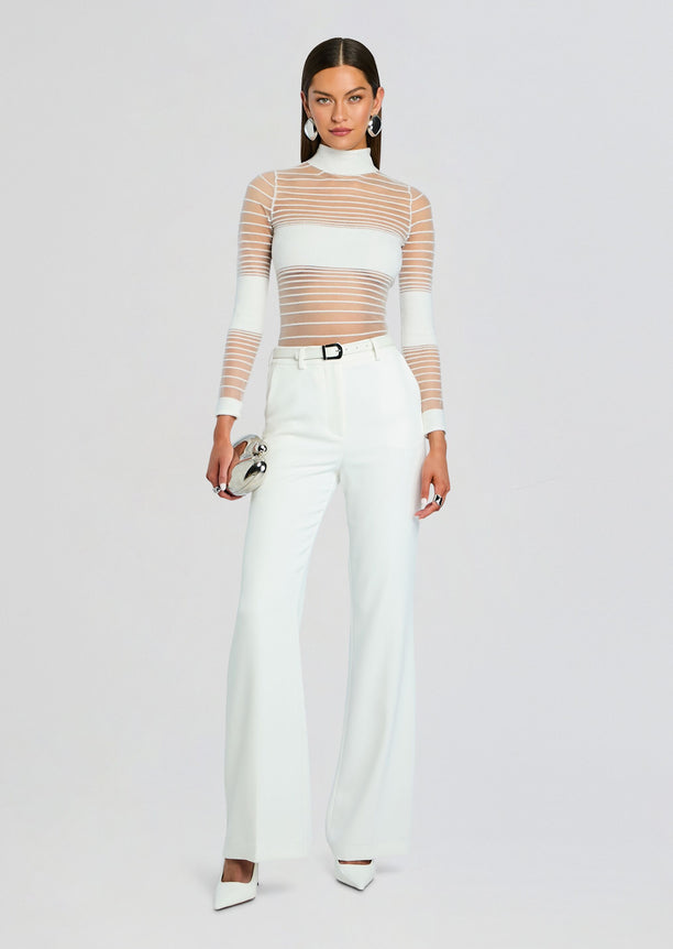 Katrine Top styled with white wide leg pants a white belt and a small silver round clutch