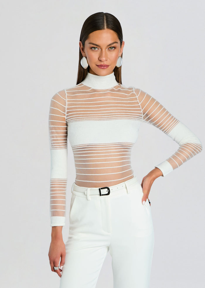 Model wearing Katrine Top a sheer white striped knit with a high neck and white pants media 1 of 5
