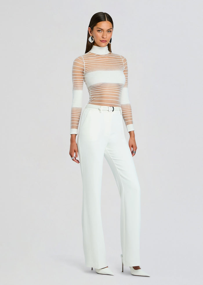 Model wearing Katrine Top a sheer striped white long sleeve top paired with white trousers and heels media 4 of 5