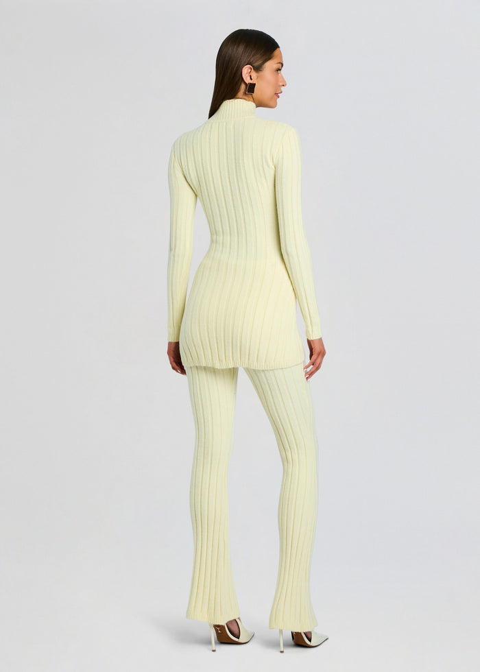Back view of a model wearing a pale yellow Velira Knit Pant set with a long ribbed sweater and flared pants. media 5 of 5