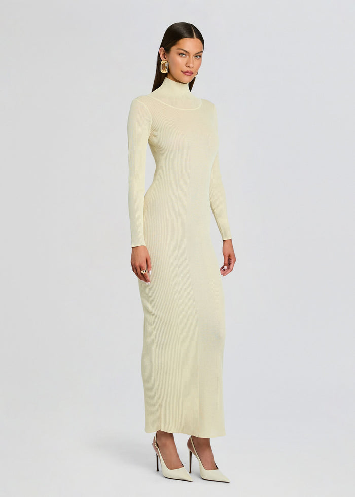 Front view of a woman in a cream ribbed knit maxi dress with a turtleneck long sleeves and white heels media 3 of 5