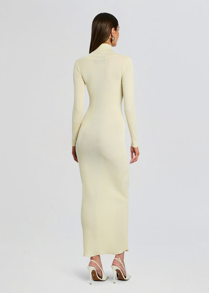 Back view of a woman in a cream ribbed knit maxi dress with a high neck slim silhouette and full length media 4 of 5