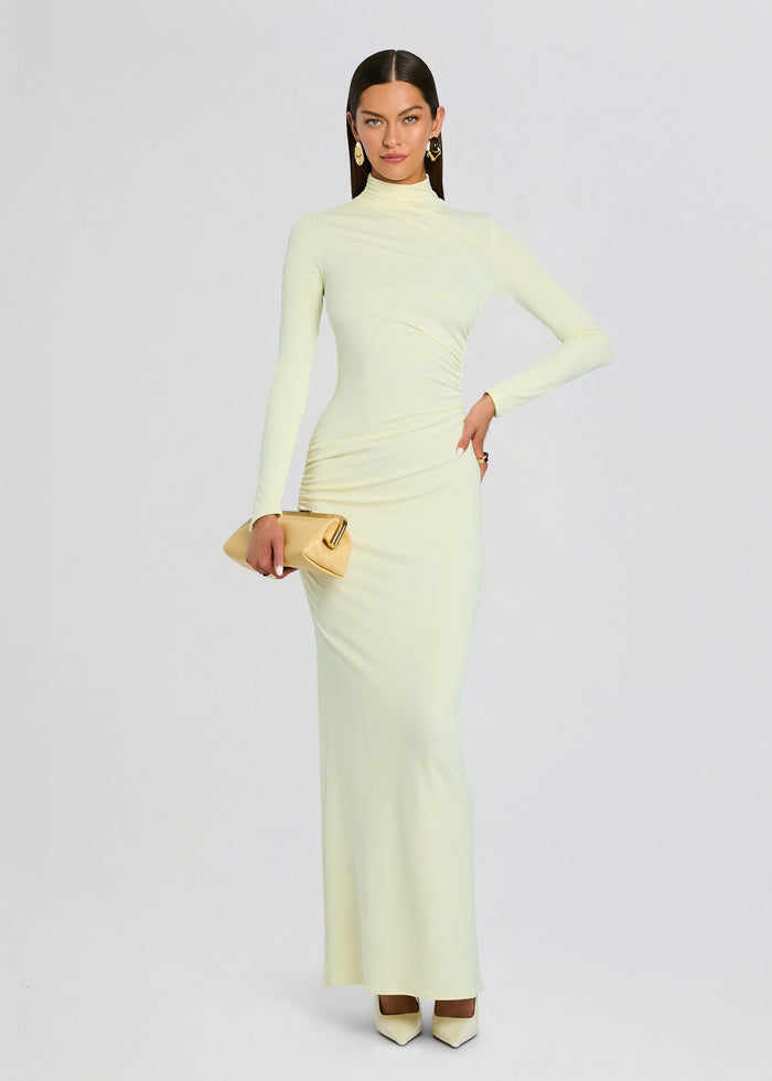 Oona Maxi Dress in pale yellow with a high neckline long sleeves and a ruched waist, shown with a beige clutch media 5 of 5