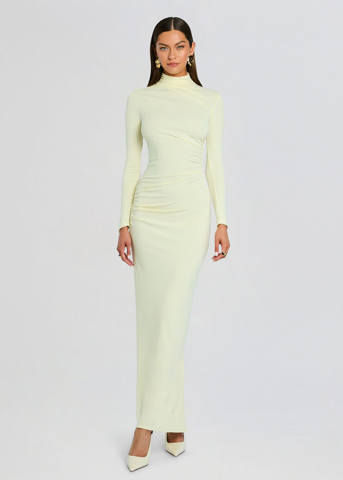Model in pale green Oona Maxi Dress with a high neckline and ruched waist, paired with cream heels media 1 of 5