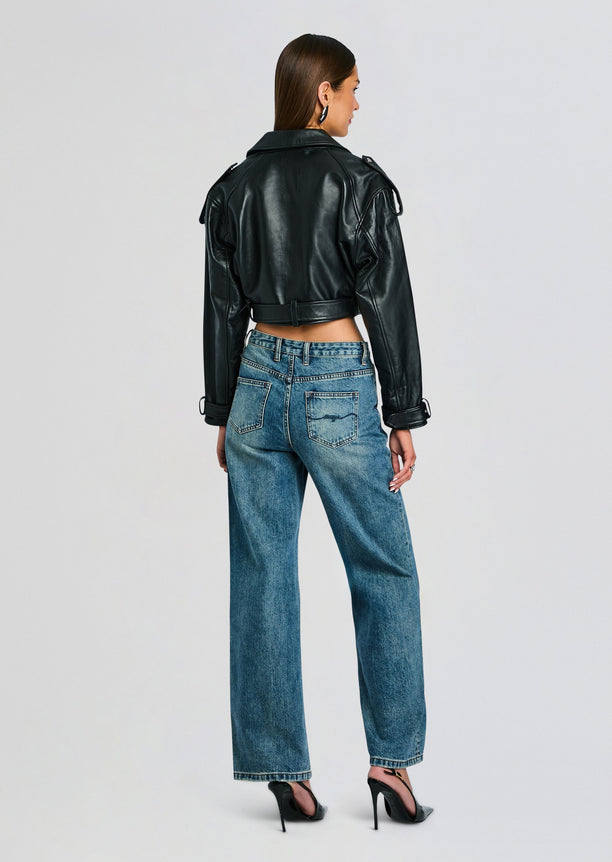 Back view of a cropped black leather jacket with belt worn over high waist jeans