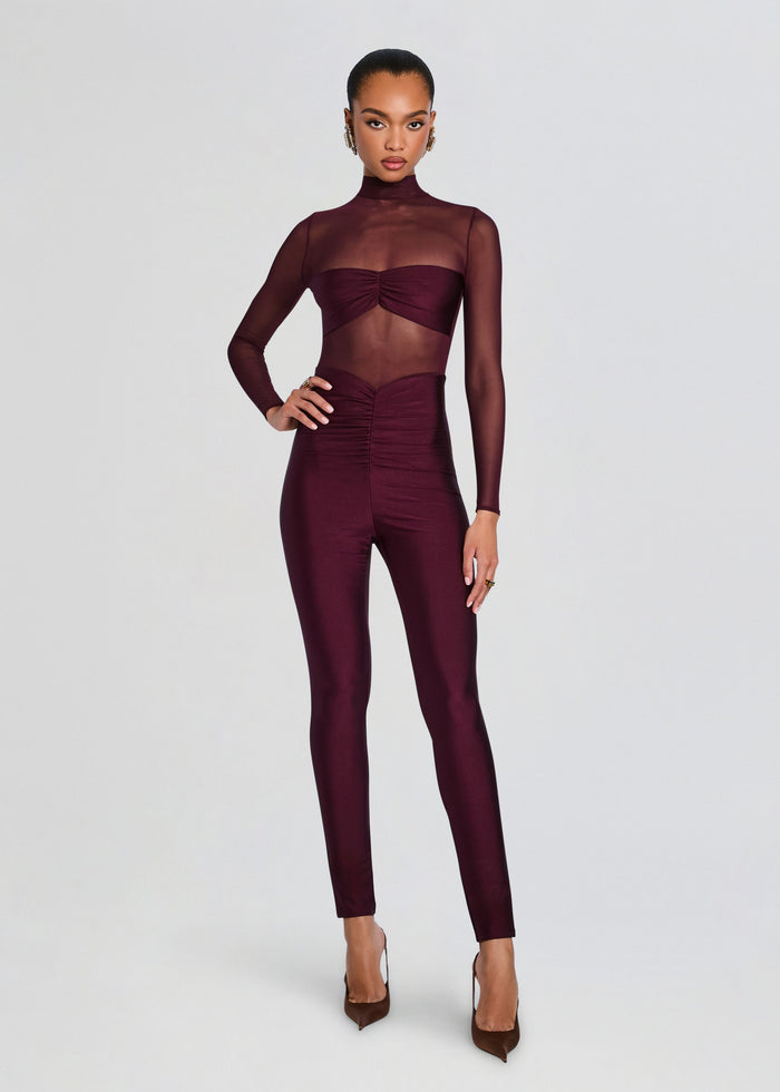 Full length view of a model wearing Brietta Bandeau Mesh Catsuit in burgundy with sheer mesh sleeves and ruched bandeau bodice. media 1 of 5