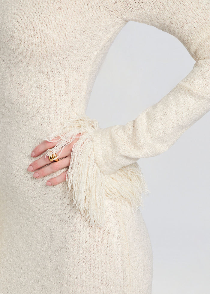 Close-up of the cream knit fabric and fringe detail at the sleeve of the Carina Maxi Dress media 2 of 5