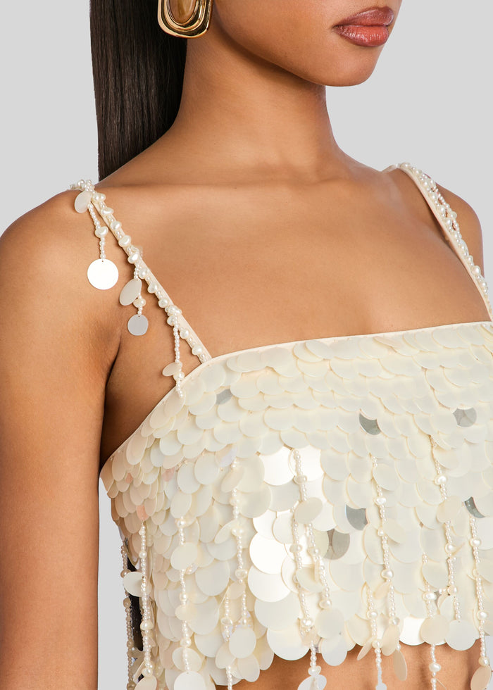 Close up of ivory sequined top with pearl strap detailing and circular disc embellishments media 3 of 6