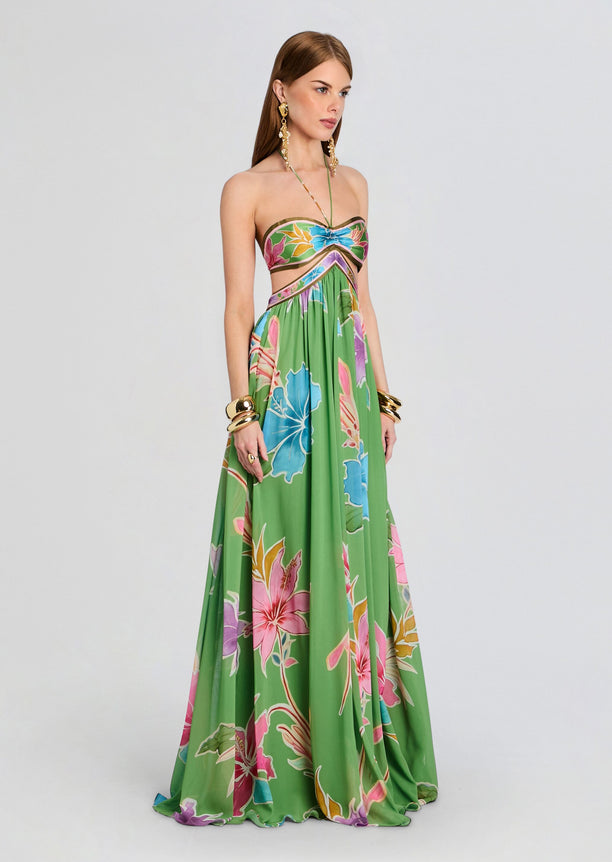 Full length view of the Rabel Dress on model featuring a bandeau floral top and flowing green tropical skirt with halter neck tie.