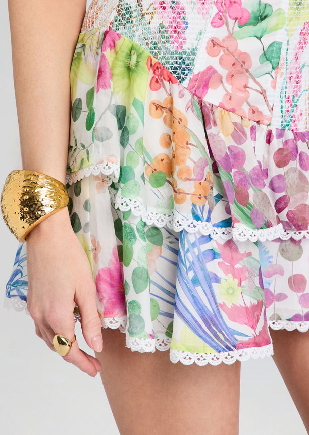 Close up of Sora Short Dress with vibrant floral print and white lace hem.