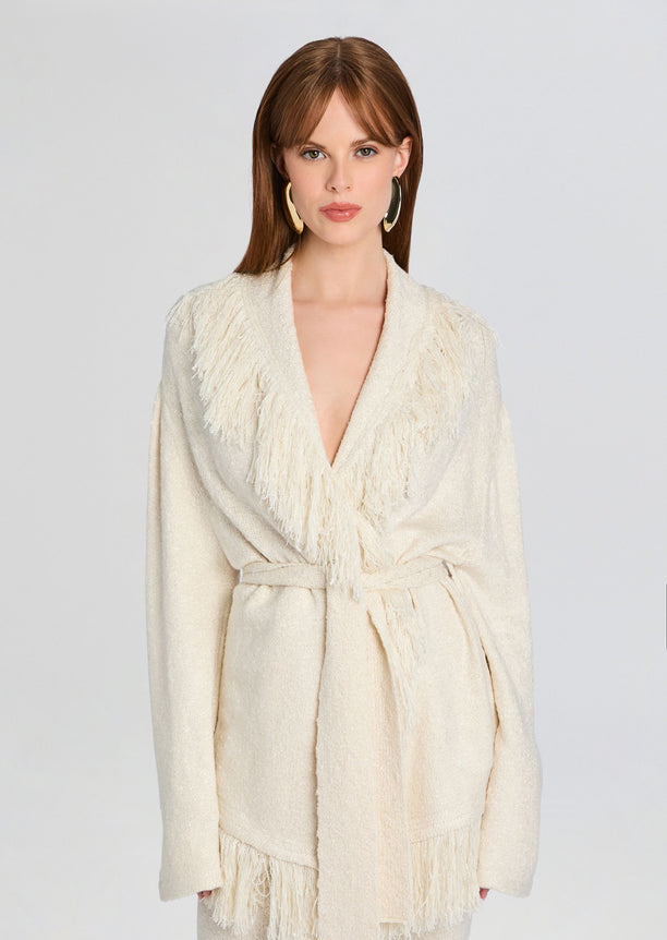 Model wearing cream Winslet Cardigan with fringe trim and a belt at the waist.