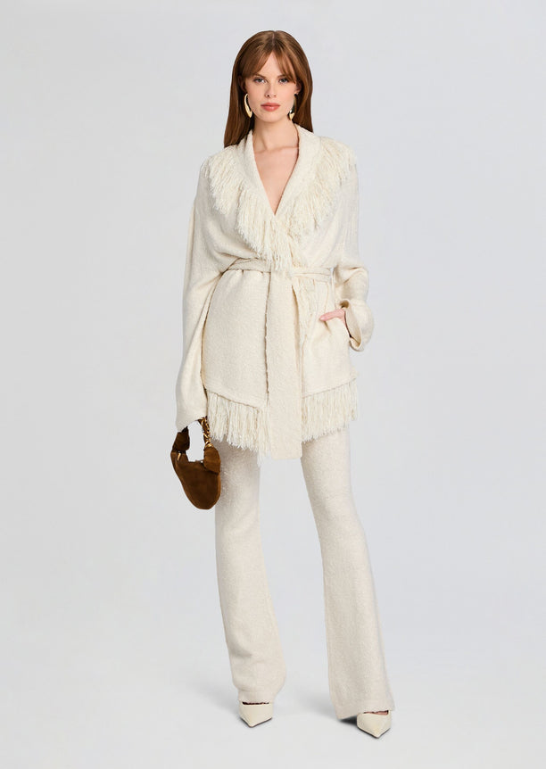 Full body view of model in cream Winslet Cardigan with fringe trim, matching pants, and a brown handbag.