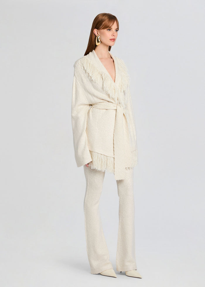 Full-body view of model in ivory Zadie Knit Pant outfit with fringed wrap cardigan belted over matching pants. media 4 of 5