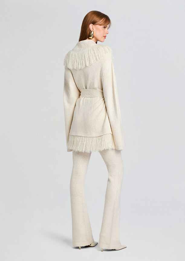 Back view of cream Winslet Cardigan with fringe across the shoulders and hem belted over matching knit pants