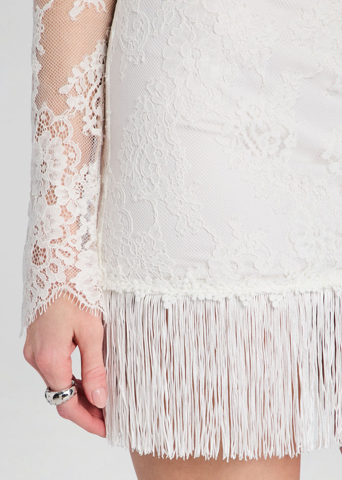 Close-up of white lace fabric and fringe hem on the Xylina Lace Dress. media 2 of 5