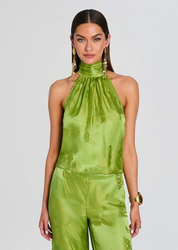 Front view of model wearing lime green Martana Top with a high halter neckline and tropical satin print.