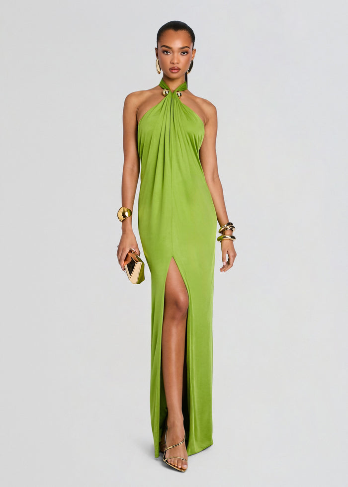 Model wearing a lime green halter neck gown with a thigh high slit, accessorized with gold jewelry and a small clutch. media 1 of 5