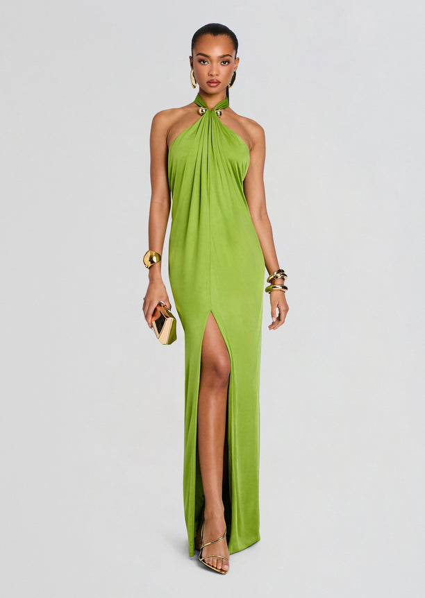 Model wearing a lime green halter neck gown with a thigh high slit, accessorized with gold jewelry and a small clutch.