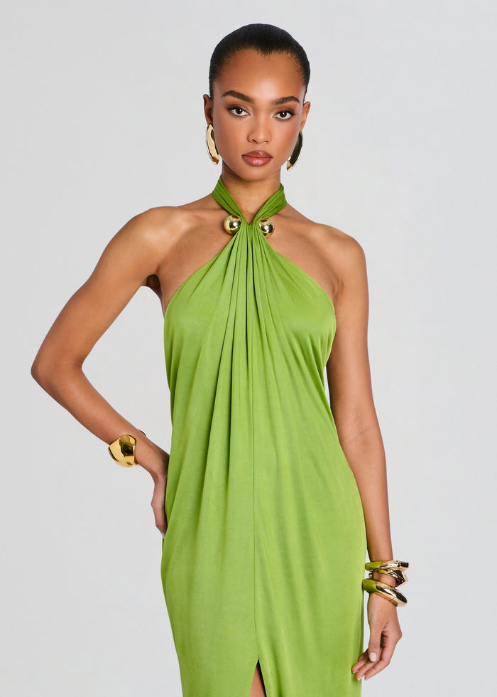 Lime green halter neck dress with twisted neckline and draped front, styled with bold gold jewelry. media 5 of 5