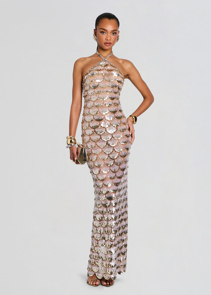Model wearing a champagne sequin gown with scallop scale pattern and a halter neckline. media 1 of 5