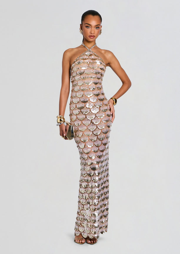Model wearing a champagne sequin gown with scallop scale pattern and a halter neckline.