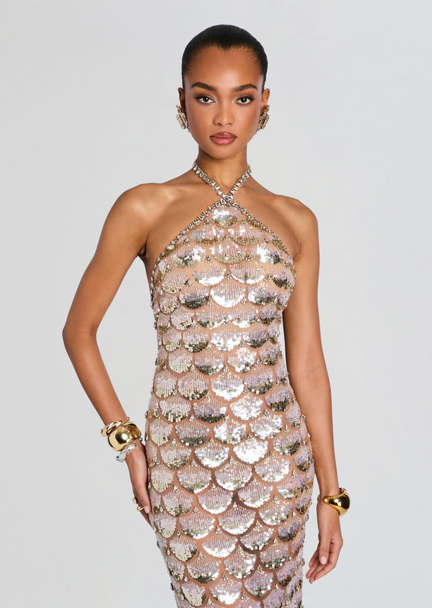 Model wearing a rose gold sequined halter dress with scalloped shell pattern and crystal embellishments