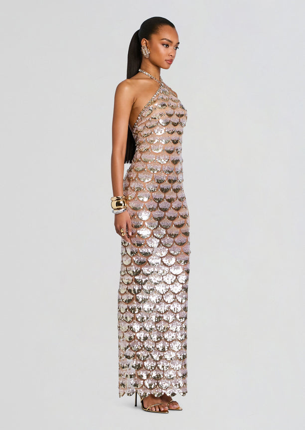 Side view of a model wearing the Genovia Embroidered Dress halter neck gown covered in pink and silver sequins.