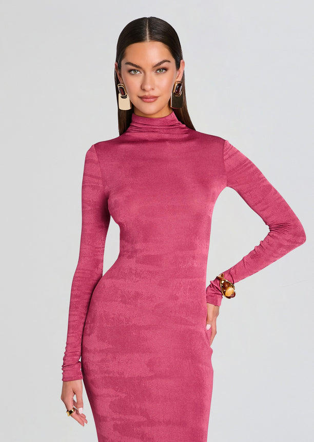 Model wearing a pink velvet long sleeve turtleneck maxi dress with a bodycon fit