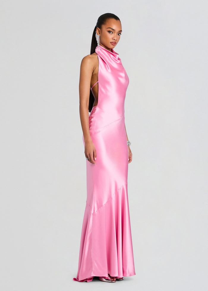 Side view of a model in a pink satin Luneth Dress with a halter neck and open back. media 3 of 5